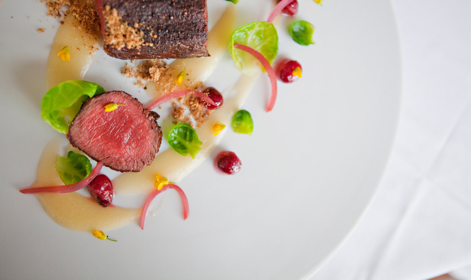 sliced steak with garnishing on a white plate