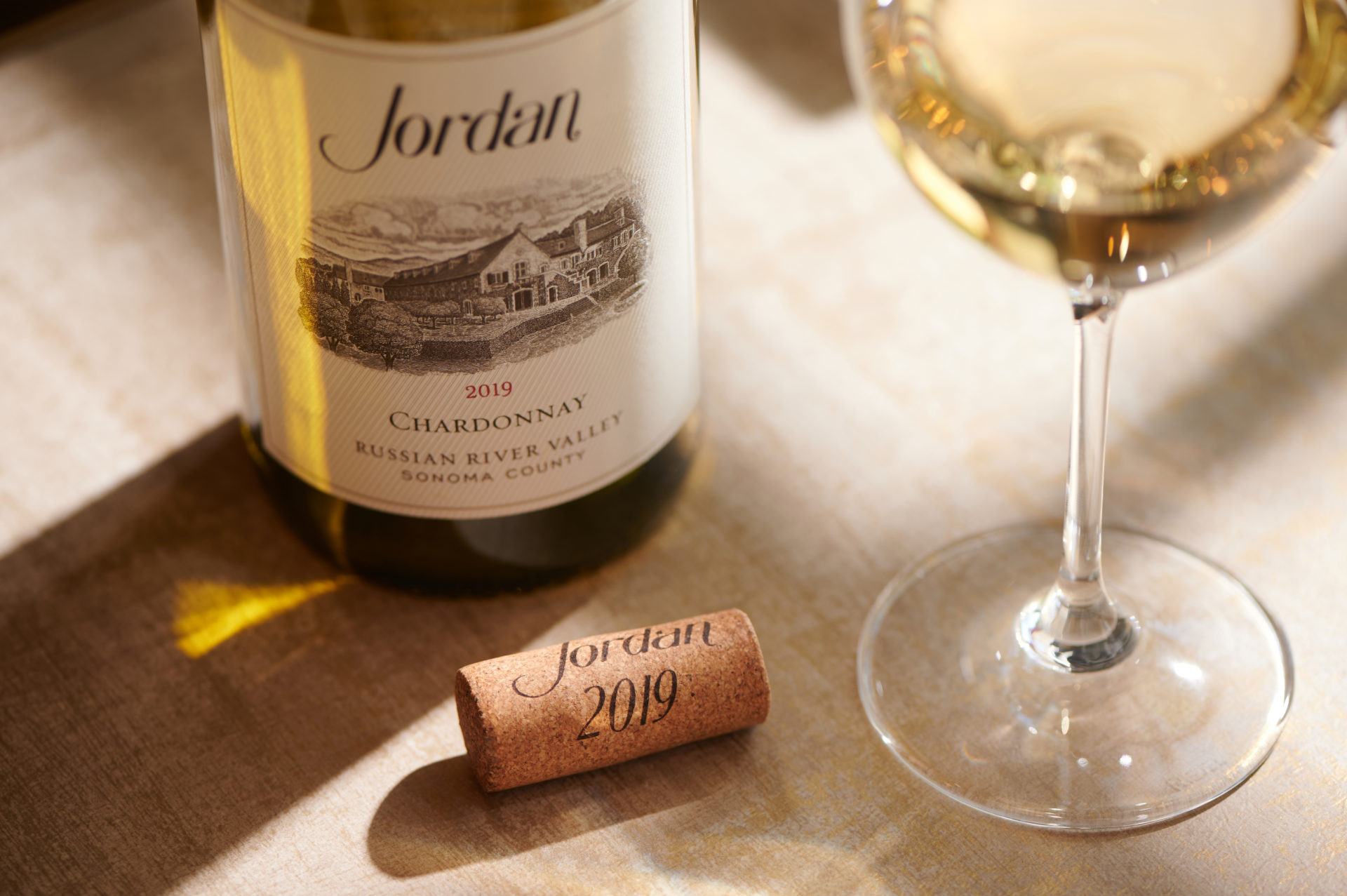 Bottle of Jordan Chardonnay, cork, and wine glass