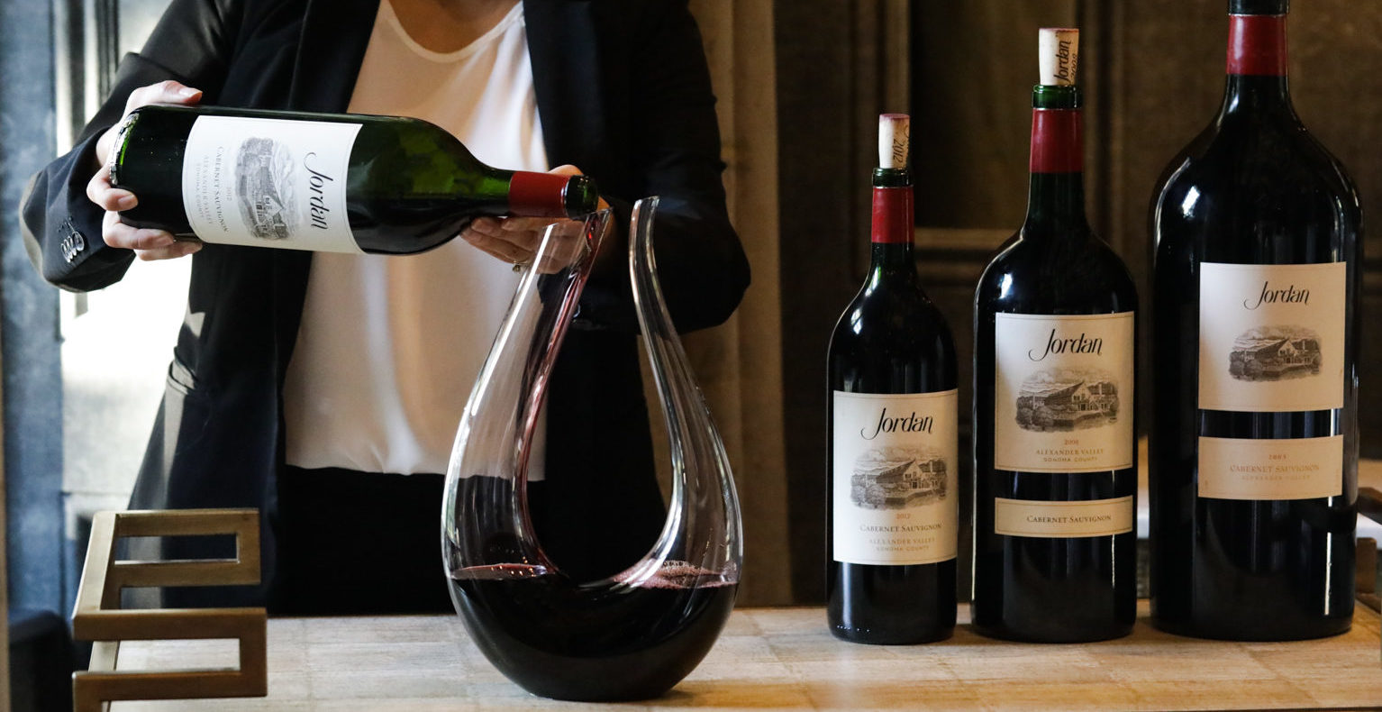 sommelier pouring magnum of cabernet wine into a decanter