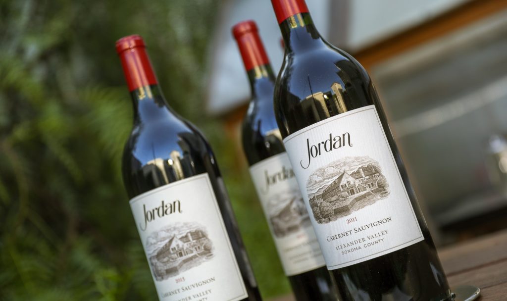 three bottles of jordan cabernet magnum bottles on a table