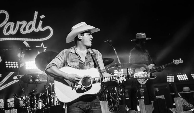 black and white photo of country star Jon Pardi holding his guitar on stage