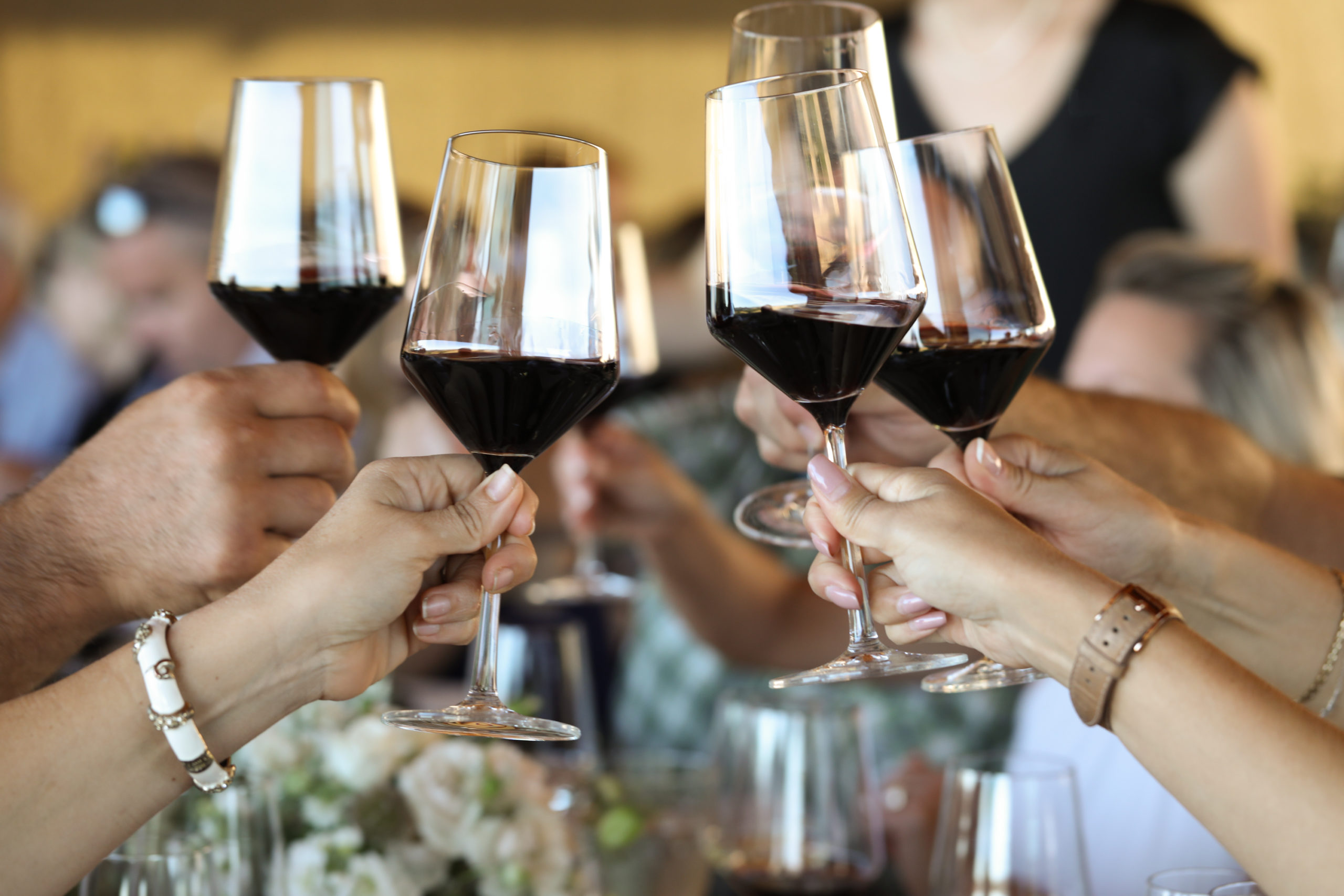 group of wine glasses toasting at the dinner table