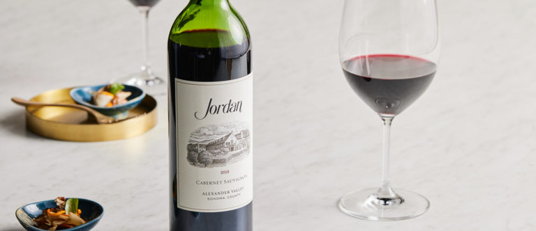 bottle of red wine on marble table with glass of red wine