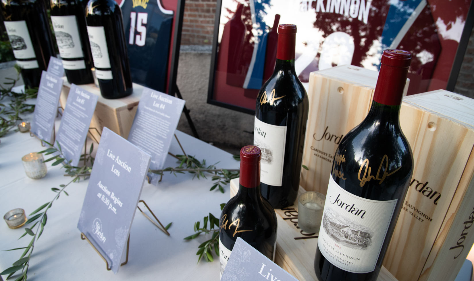 signed wine bottles and sports memorabilia on display for silent auction