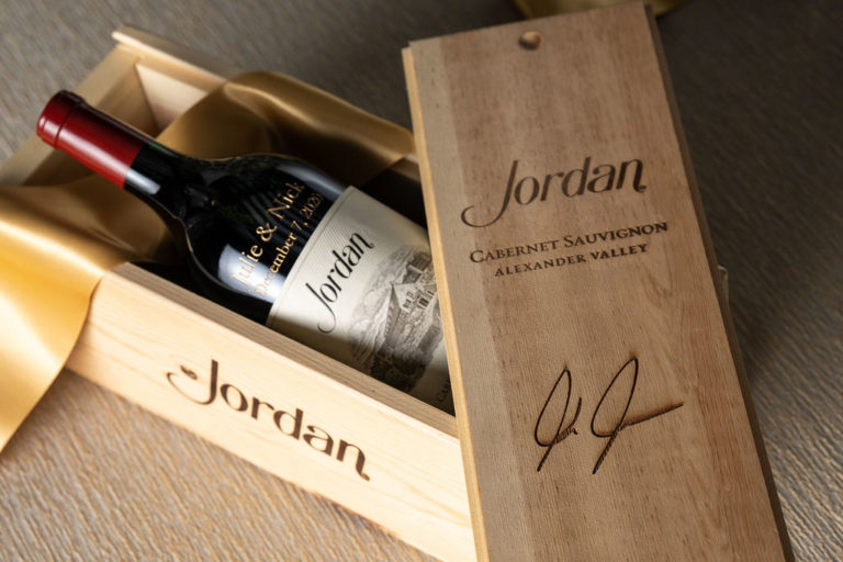 Etched magnum bottle in wooden gift box with decorative gold ribbon over bottle