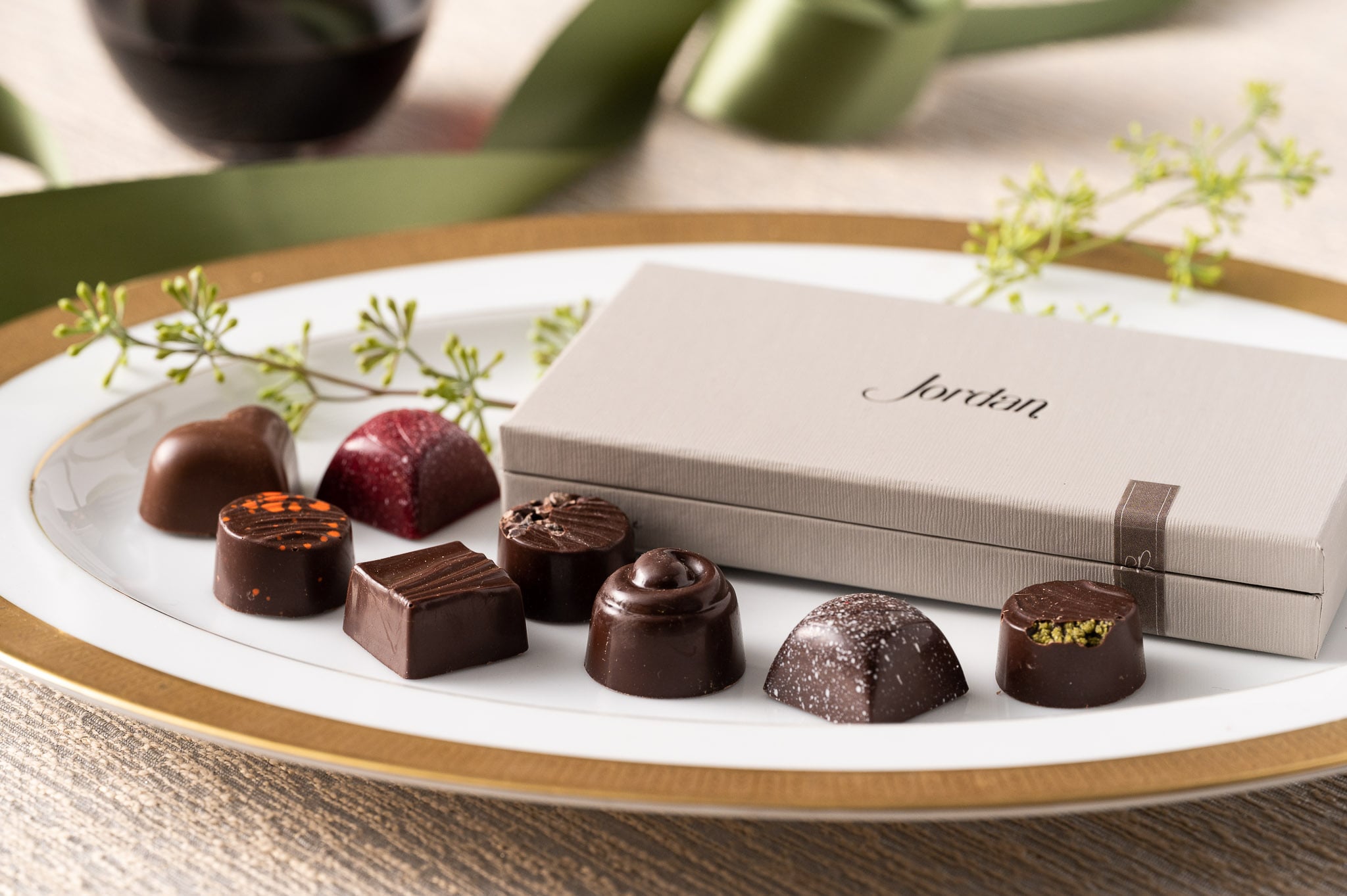 selection of chocolates next to gift box resting on a plate