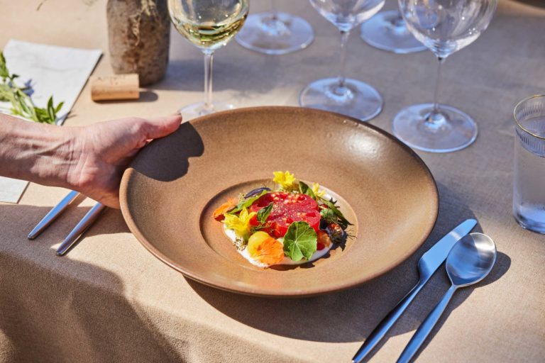 dinner dish with tomato and wine glasses on table