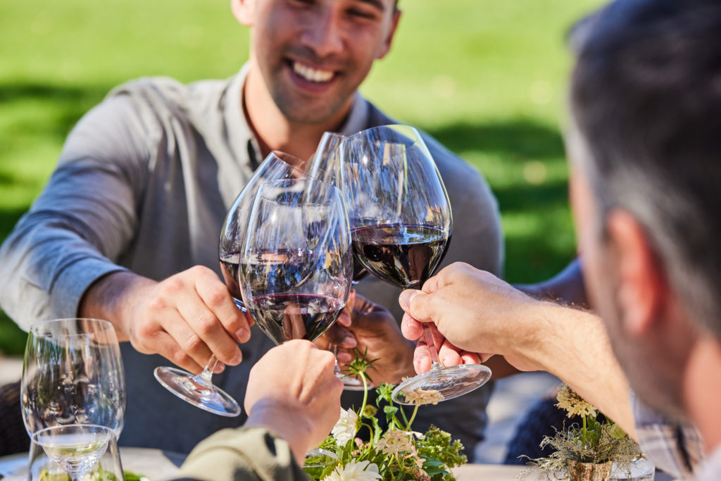 four glasses of cabernet sauvignon toasting at table