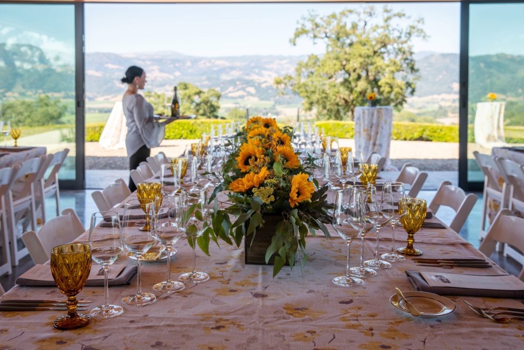 Dinner table set with sunflowers and floral tablecloth
