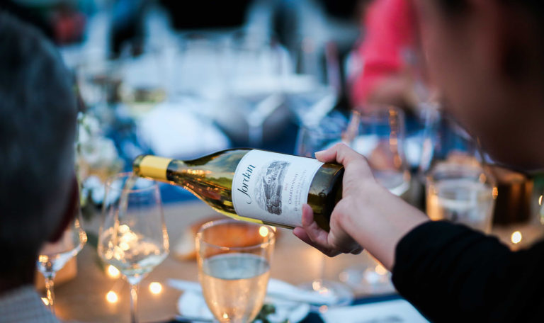Jordan Chardonnay bottle pouring at outdoor dinner