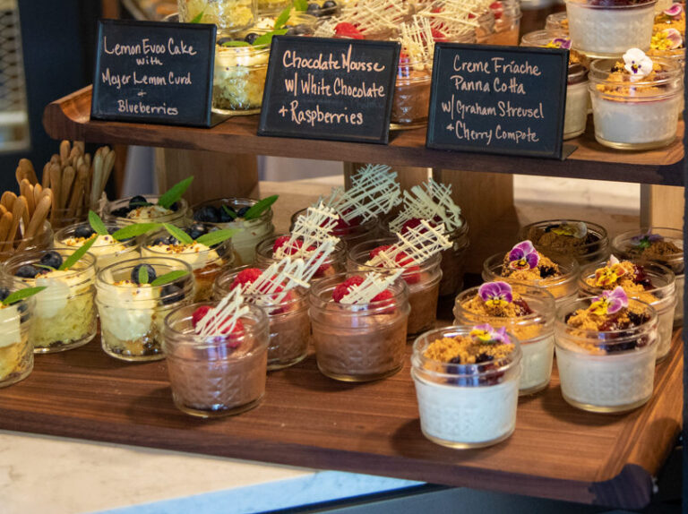 mason jars filled with small desserts and pickled vegetables on table