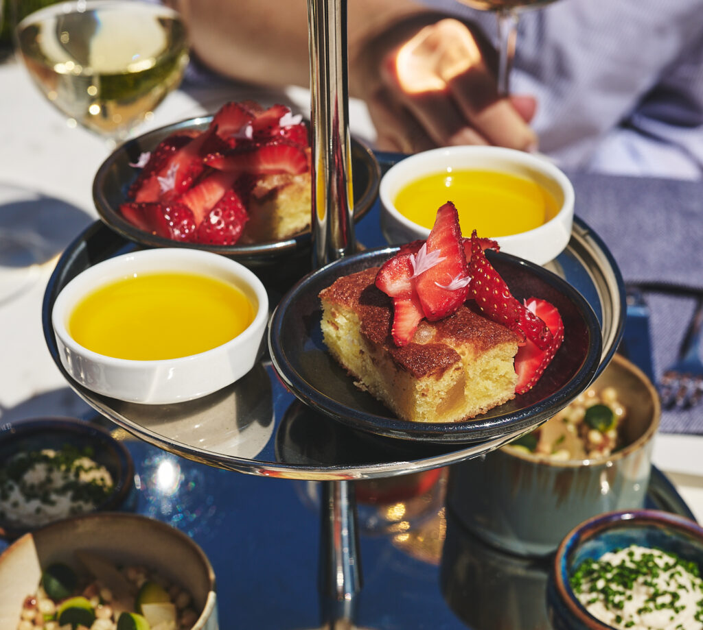 small appetizers on silver tiers on outdoor bistro table