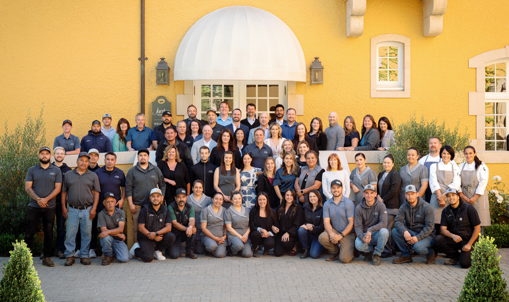 The extended Jordan family of employees standing for a group photo in courtyard of winery