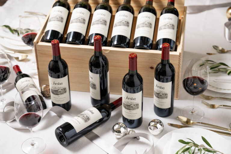 wooden box gift set of twelve bottles of jordan cabernet with christmas decorations arranged about the box