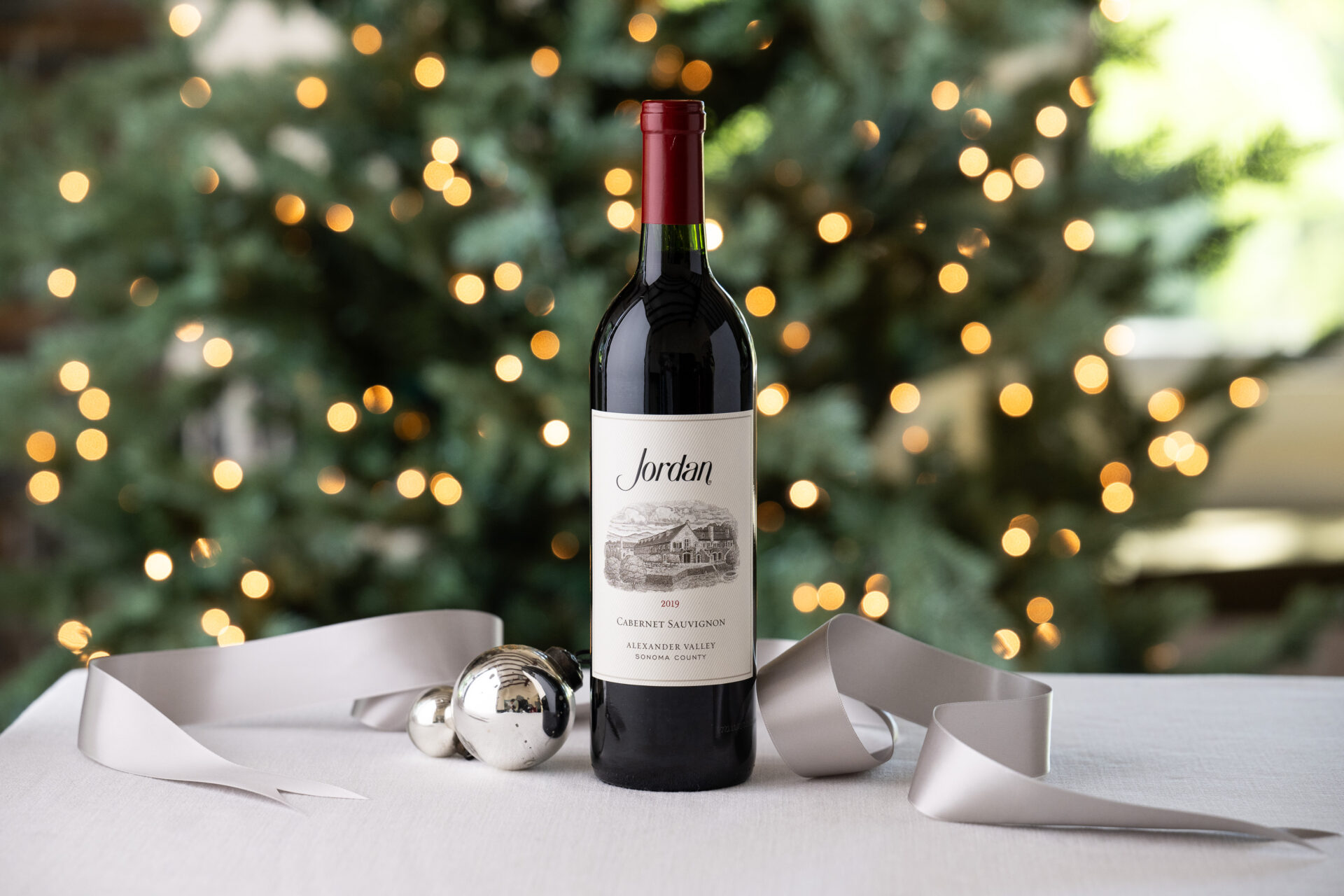 jordan cabernet sauvignon on table with silver christmas ornaments and ribbon in front of christmas tree
