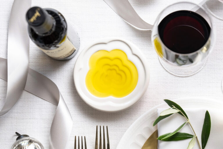 terraced olive oil dipping dish on white table cloth filled with olive oil