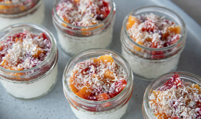 yogurt parfait in mason jars on a blue platter