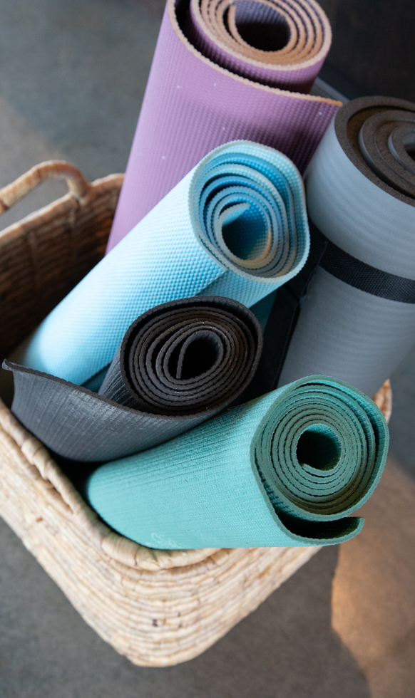 rolled up yoga mats in a basket