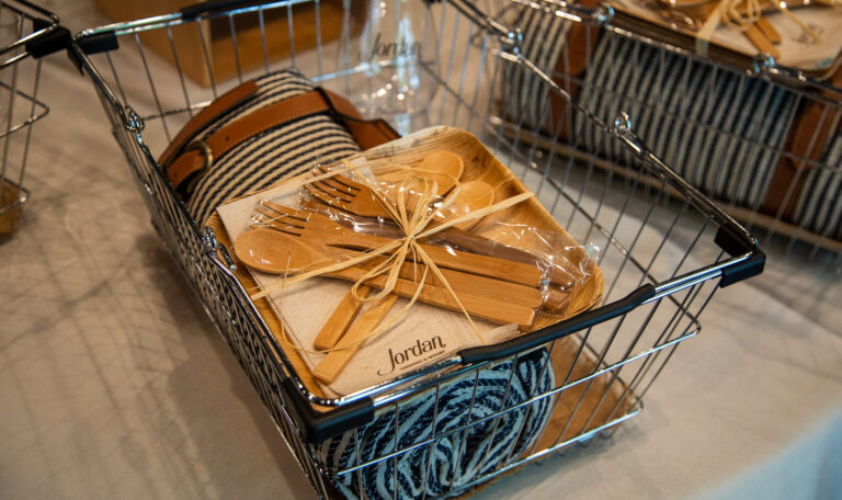 metal wire picnic basket filled with compostable plates and cutlery for picnics