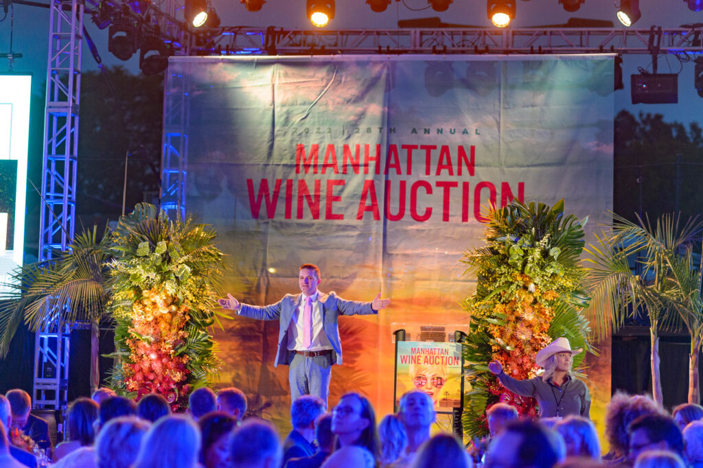 auctioneer on main stage of manhattan beach wine auction at night