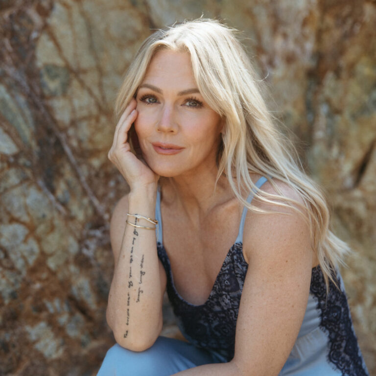 blonde woman sitting on rock