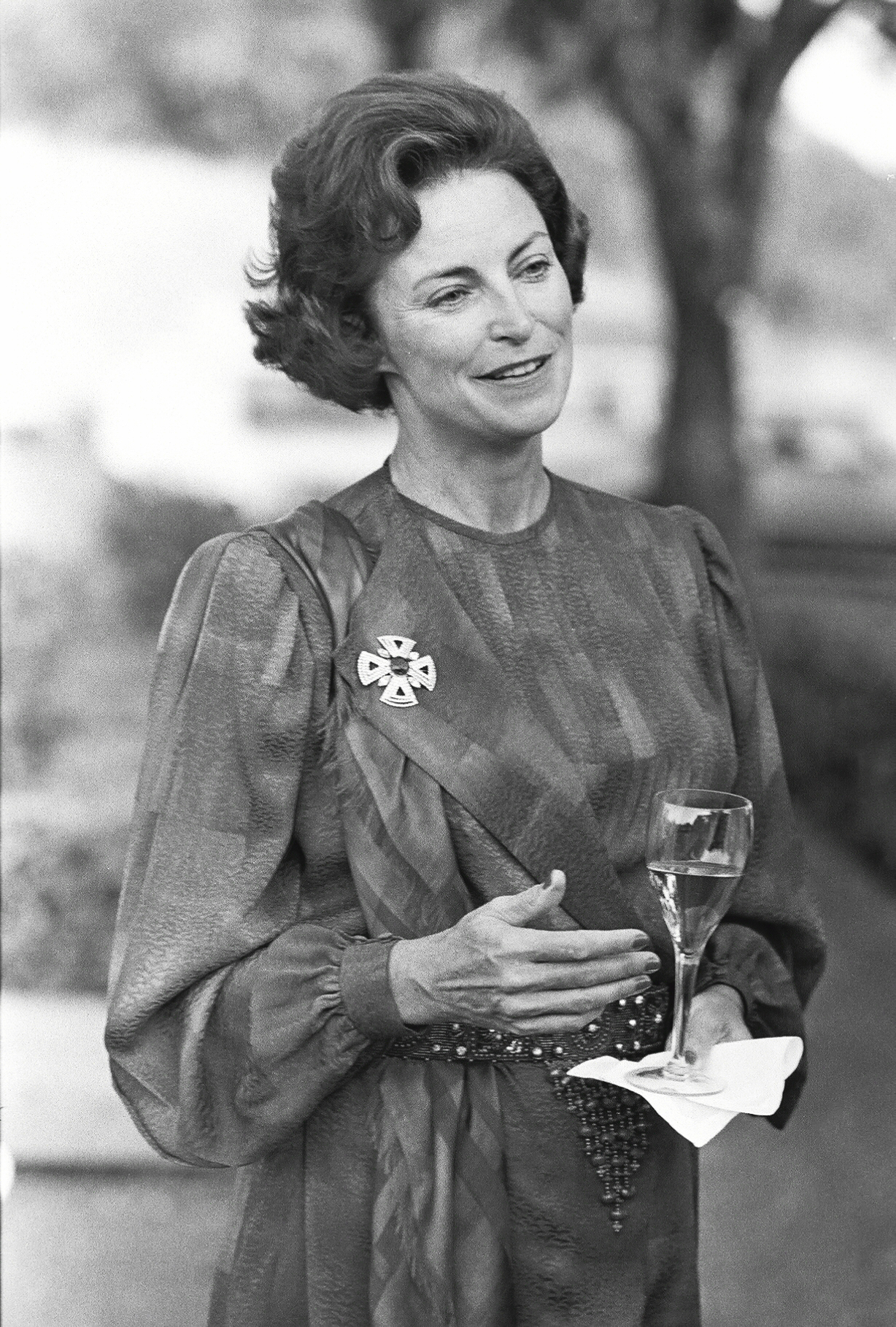 black and white photo of woman holding glass of champagne