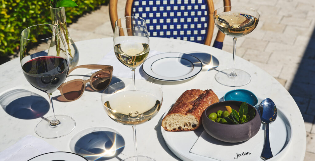 olive and bread with glasses of wine on outdoor bistro table