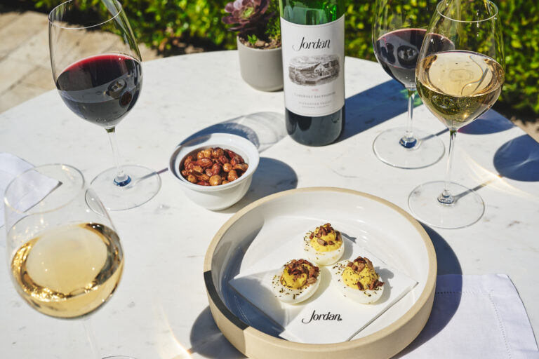 deviled eggs on bistro table with wines in glasses