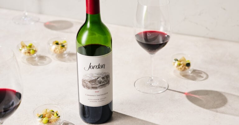 bottle of cabernet with small bites and glasses of red wine
